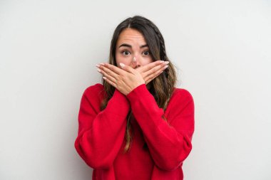 Beyaz arka planda izole edilmiş beyaz tenli genç bir kadın elleri endişeli bir şekilde ağzı örtüyor..