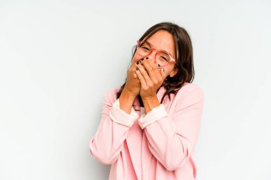 Mavi arka planda izole edilmiş genç İspanyol kadın ellerini çenesinin altında tutuyor ve mutlu bir şekilde yan tarafa bakıyor..