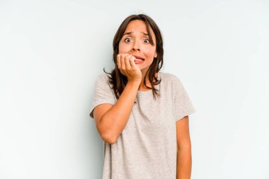 Genç İspanyol kadın mavi arka planda yalnız dans ediyor ve eğleniyor..