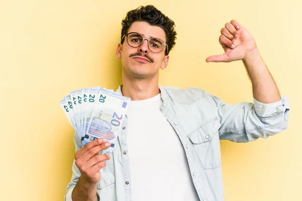 Young Caucasian Man Holding Banknotes Isolated Yellow Background Feels Proud — ストック写真