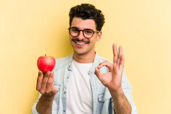 Young Caucasian Man Holding Apple Isolated Yellow Background Cheerful Confident — Foto de Stock
