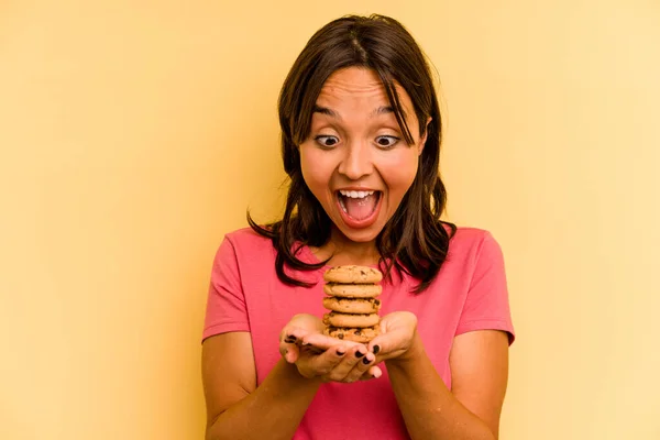 Young Hispanic Woman Holding Cookies Isolated Yellow Background — Stok fotoğraf