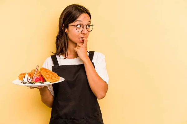 Jovem Hispânico Dependente Mulher Segurando Waffles Isolado Fundo Amarelo Relaxado — Fotografia de Stock