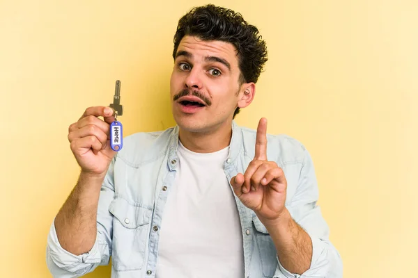 Young Caucasian Man Holding Home Keys Isolated Yellow Background Having — Fotografia de Stock