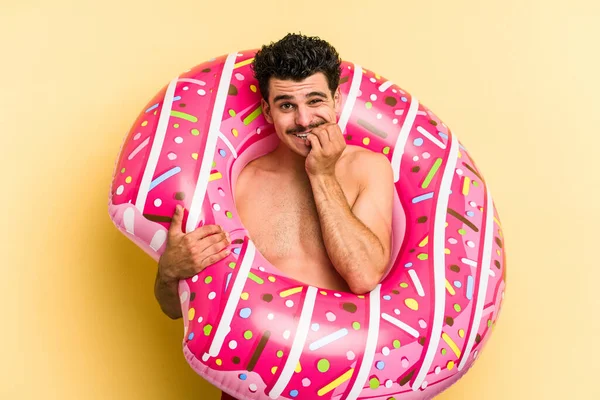 Young Caucasian Man Holding Inflatable Donut Isolated Yellow Background Biting — 图库照片
