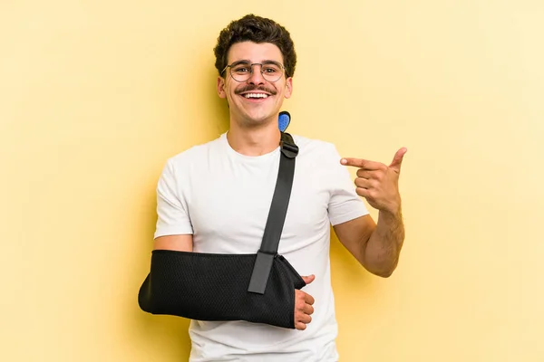 Young Caucasian Man Broke Hand Isolated Yellow Background Person Pointing — Stock Fotó