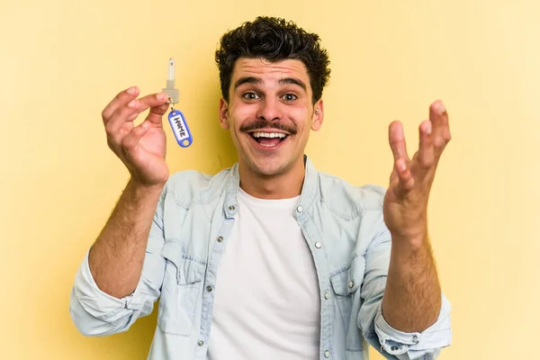 Young Caucasian Man Holding Home Keys Isolated Yellow Background Receiving — Stockfoto