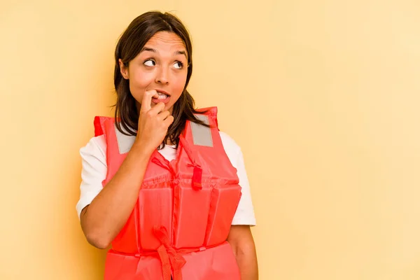 Ung Latinamerikansk Kvinna Håller Flytväst Isolerad Gul Bakgrund Avslappnad Tänka — Stockfoto