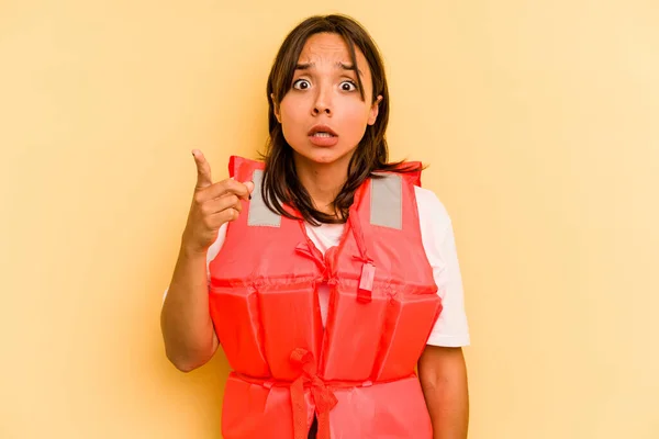 年轻的惊慌失措的女人 穿着黄色背景的救生衣 有想法 有灵感 — 图库照片