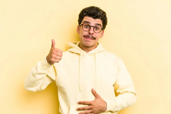 Young Caucasian Man Isolated Yellow Background Touches Tummy Smiles Gently — Stock Photo, Image