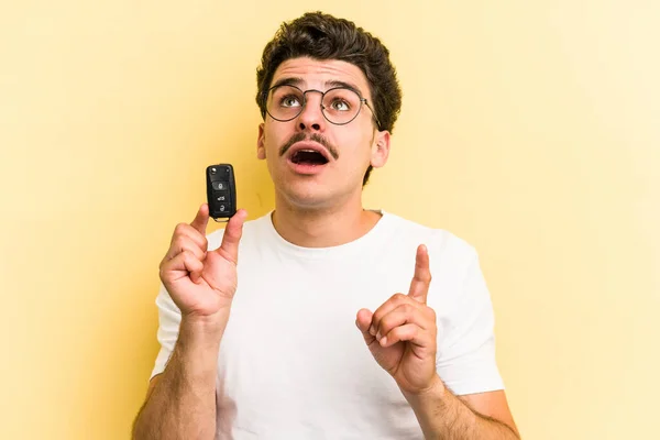 Young Caucasian Man Holding Car Keys Isolated Yellow Background Pointing — Foto de Stock