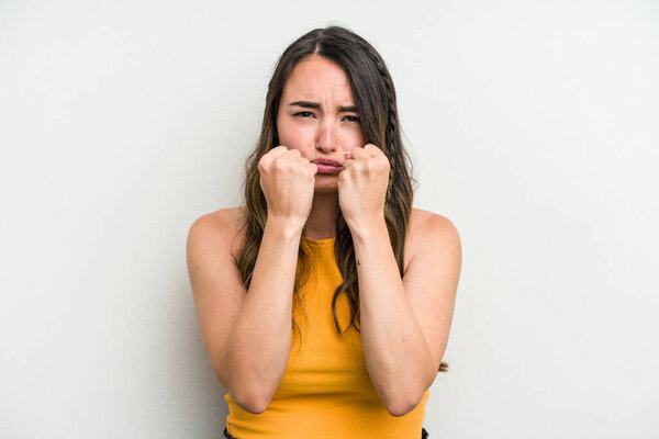 Young caucasian woman isolated on white background showing fist to camera, aggressive facial expression.