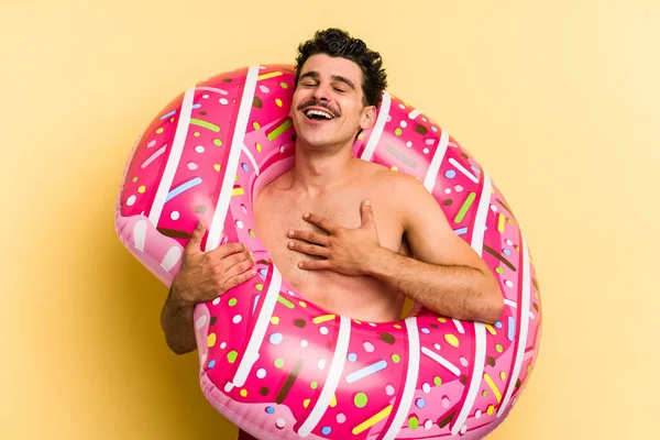 Young Caucasian Man Holding Inflatable Donut Isolated Yellow Background Laughs — 图库照片