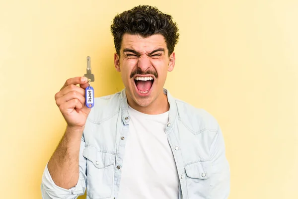 Young Caucasian Man Holding Home Keys Isolated Yellow Background Screaming — Stockfoto