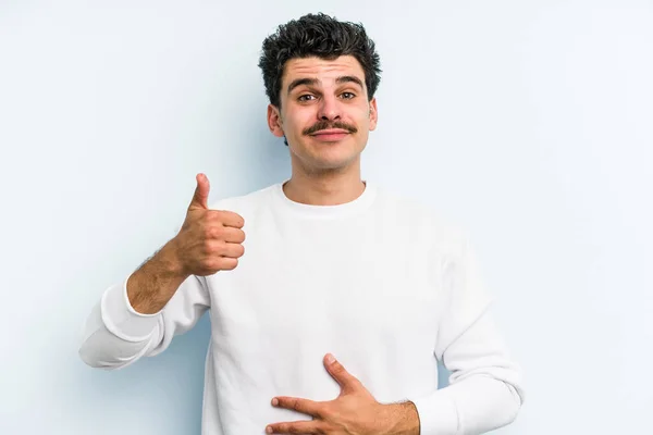 Young Caucasian Man Isolated Blue Background Touches Tummy Smiles Gently — Stock Photo, Image