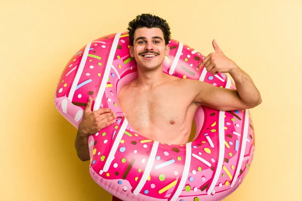 Young Caucasian Man Holding Inflatable Donut Isolated Yellow Background Person — ストック写真