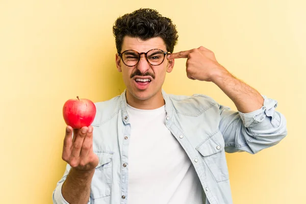 Young Caucasian Man Holding Apple Isolated Yellow Background Showing Disappointment — Foto de Stock