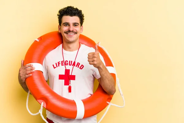 Young Caucasian Lifeguard Man Isolated Yellow Background Smiling Raising Thumb — ストック写真
