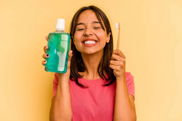 Young Hispanic Woman Holding Mouthwash Isolated Yellow Background — Stock fotografie