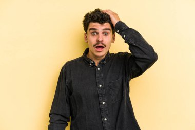 Sarı arka planda izole genç beyaz adam şok oldu, o önemli bir toplantı hatırladı.