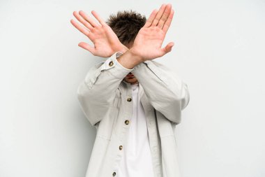 Beyaz arka planda izole genç beyaz adam iki kolu çapraz tutuyor, inkar kavramı.