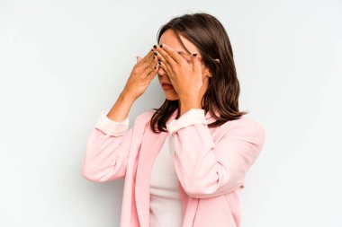 Mavi arka planda izole edilmiş genç İspanyol kadın hedeflerine ve amaçlarına ulaşmayı hayal ediyor.