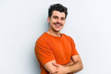 Mavi arka planda izole edilmiş genç beyaz adam mutlu, güler yüzlü ve neşeli.