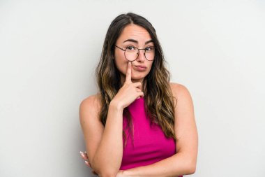 Beyaz arka planda izole edilmiş beyaz bir kadın mutsuz bir şekilde alaycı bir ifadeyle kameraya bakıyor..