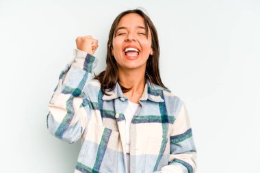 Genç İspanyol kadın mavi arka planda izole edilmiş. Kendine güvenen, ellerini kalçasında tutan..