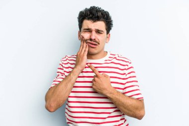 Mavi arka planda izole genç beyaz adam güçlü bir diş ağrısı, azıdişi ağrısı var..