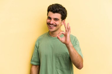 Genç beyaz adam sarı arka planda izole edilmiş neşeli ve kendinden emin..