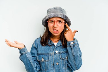 Mavi arka planda soyutlanmış genç İspanyol kadın elleriyle gözlerini kapatıyor, geniş bir gülümsemeyle bir sürpriz bekliyor..