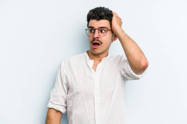 Mavi arka planda izole genç beyaz adam şok oldu, o önemli bir toplantı hatırladı.