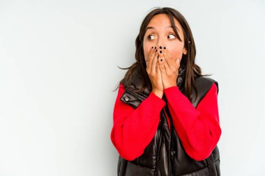 Mavi arka planda izole edilmiş genç İspanyol kadın yanakları patlatıyor, yorgun bir ifadesi var. Yüz ifadesi kavramı.