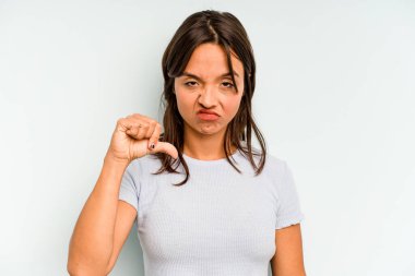 Genç İspanyol kadın mavi arka planda izole edilmiş, parmağıyla tapınağı işaret ediyor, düşünüyor, bir göreve odaklanıyor..