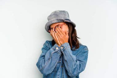 Genç İspanyol kadın mavi arka planda izole edilmiş parmaklarıyla kulaklarını kapatıyor, gürültülü bir ortam yüzünden stresli ve çaresiz..