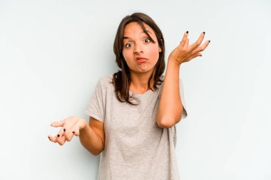 Mavi arka planda izole edilmiş genç İspanyol kadın özel bir günü kutluyor, atlıyor ve enerjiyle kollarını kaldırıyor..