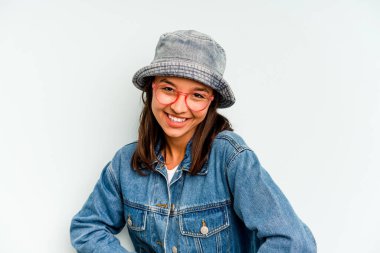 Mavi arka planda izole edilmiş genç İspanyol kadın şok olmuş, ağzı ellerle kaplanmış, yeni bir şey keşfetmeye hevesli..