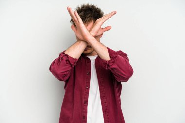 Beyaz arka planda izole genç beyaz adam iki kolu çapraz tutuyor, inkar kavramı.