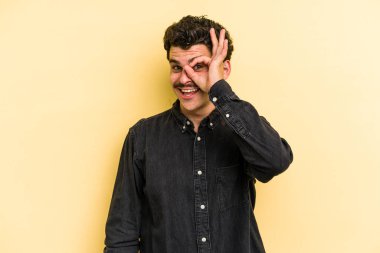 Kafkasyalı genç adam sarı arka planda izole edilmiş. Heyecanlı..