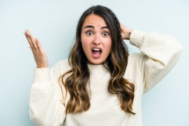 Mavi arka planda izole edilmiş beyaz bir kadın öfkeyle bağırıyor..