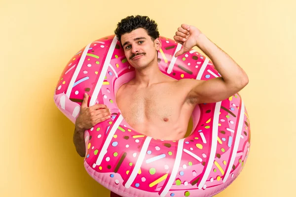 Young Caucasian Man Holding Inflatable Donut Isolated Yellow Background Feels —  Fotos de Stock