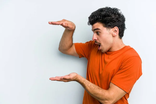 Ung Kaukasisk Man Isolerad Blå Bakgrund Chockad Och Förvånad Hålla — Stockfoto