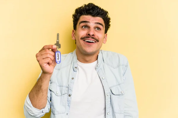 Young Caucasian Man Holding Home Keys Isolated Yellow Background Dreaming — Stock fotografie