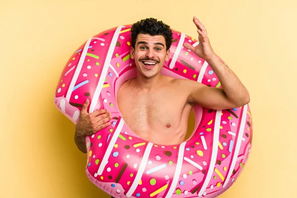 Young Caucasian Man Holding Inflatable Donut Isolated Yellow Background Receiving — 图库照片