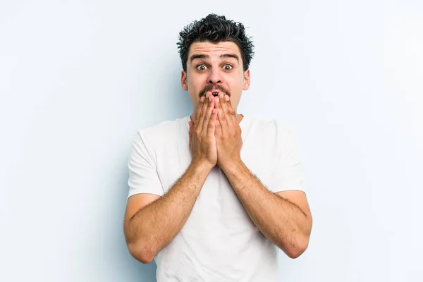 Νεαρός Καυκάσιος Άνδρας Απομονωμένος Μπλε Φόντο Σοκαρισμένος Που Καλύπτει Στόμα — Φωτογραφία Αρχείου