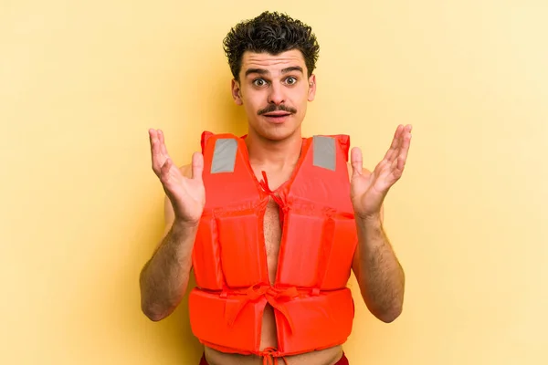 Young Caucasian Man Wearing Life Jacket Isolated Yellow Background Surprised — 图库照片