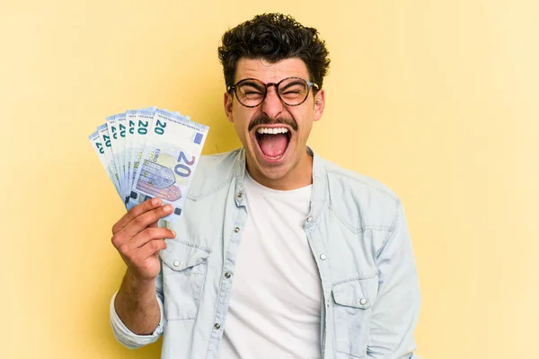 Young Caucasian Man Holding Banknotes Isolated Yellow Background Screaming Very — Foto de Stock