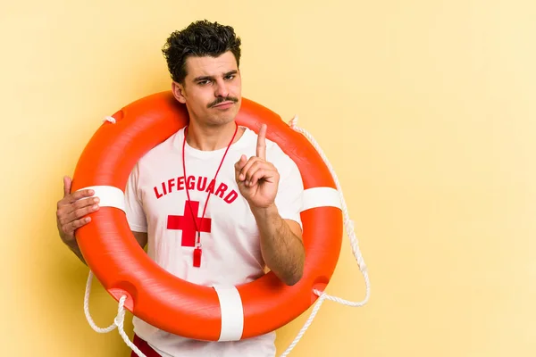 Young Caucasian Lifeguard Man Isolated Yellow Background Showing Number One — Fotografia de Stock