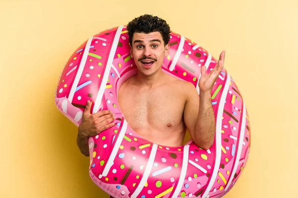 Young Caucasian Man Holding Inflatable Donut Isolated Yellow Background Surprised — 图库照片